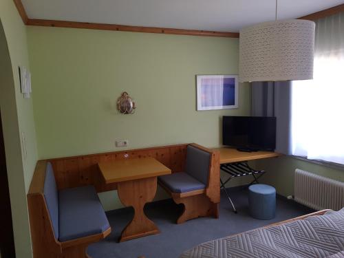 a room with a desk and a table with a computer at Pension Rangger in Radfeld