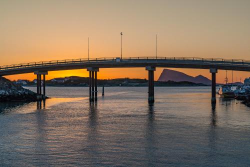 a bridge over a body of water at sunset at Sommarøy Arctic Hotel Tromsø in Sommarøy