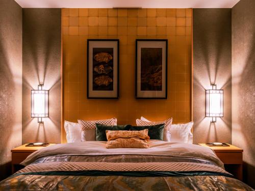 a bedroom with a large bed with two lights on it at SAMURAI HOUSE Ⅱ in Nagoya