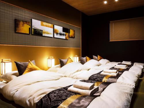 ein großes Bett in einem Zimmer mit Kissen darauf in der Unterkunft SAMURAI HOUSE Ⅱ in Nagoya