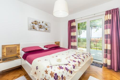 a bedroom with a bed and a large window at Apartments Marica in Skrbčići