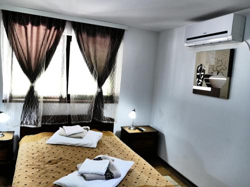 a bedroom with two beds and a window at Pensiunea Roua Florilor in Anina