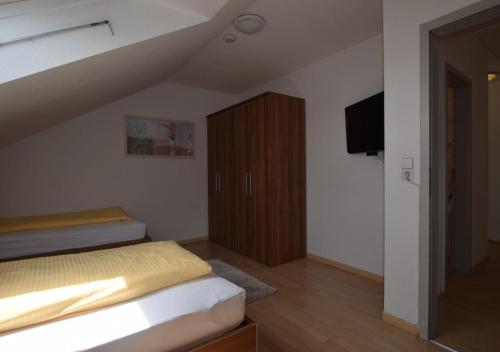 Schlafzimmer mit einem Bett und einem Holzschrank in der Unterkunft Apartment Hotel Alena in Filderstadt