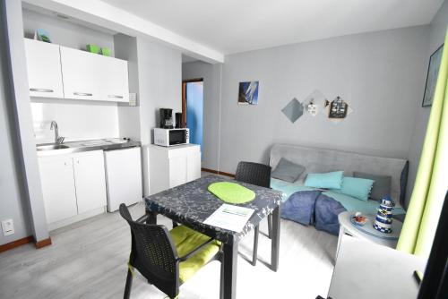ein kleines Apartment mit einem Esstisch und einer Küche in der Unterkunft Une pause… quelque part in Piriac-sur-Mer