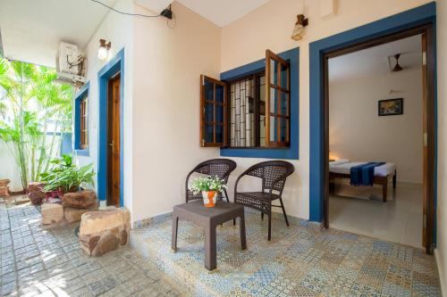 a room with two chairs and a table and a bedroom at Mistral Holidays Near Trinity Beach & Benaulim Beach in Benaulim