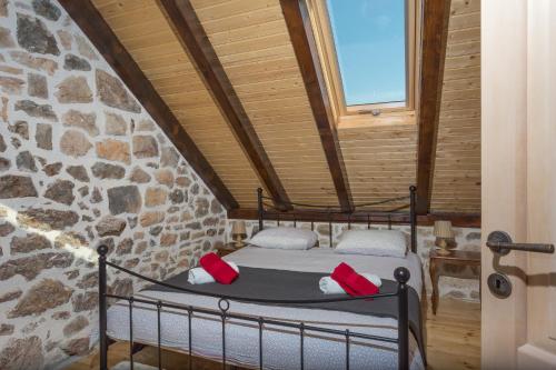 a bed in a room with a stone wall at Kuća za odmor Joko i Jeka in Bogatić
