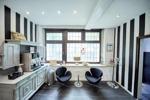 a kitchen with black and white striped walls and two chairs at Hotel Alt Deutz City-Messe-Arena KONTAKTLOSER SELF CHECK-IN in Cologne