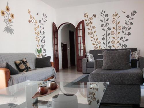 a living room with two couches and a glass table at Moradia perto dos Palmares in Lagos