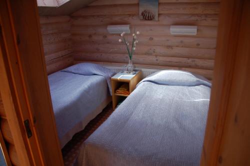 a bedroom with two beds and a table with a vase at Külalistemaja Vehendi Motell in Vehendi