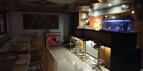 a bar in a restaurant with a fish tank on the counter at Hotel Mahendra in Jālgaon
