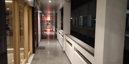 a hallway of a building with glass doors and a hallwayngth at Hotel Mahendra in Jālgaon