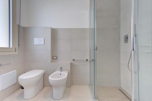 a white bathroom with a toilet and a shower at Alloggio Nella in Rimini
