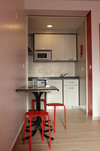 a kitchen with a table and two red stools at Baleal à Vista in Baleal