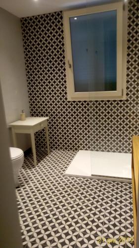 a bathroom with a black and white tile floor and a toilet at oltremare soul houses in Chiavari