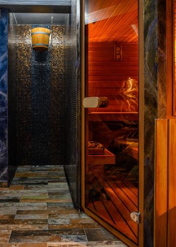 a shower in a room with a glass door at Vitality Guest House in Veliko Tŭrnovo