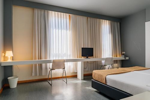 a hotel room with a bed and a desk at Basic Braga by Axis in Braga