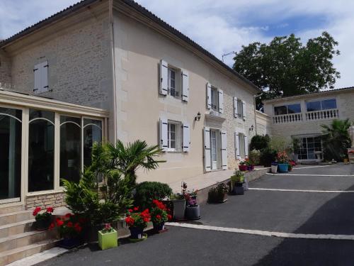 a building with potted plants on the side of it at LES ORCHIDEES Ch Hôtes B&B 14 personnes Jaunay-Clan in Jaunay-Clan