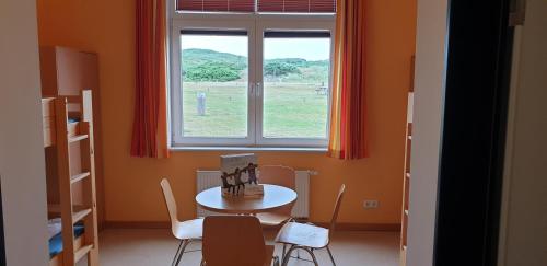 a dining room with a table and a window at Jugendherberge Westerland in Westerland (Sylt)