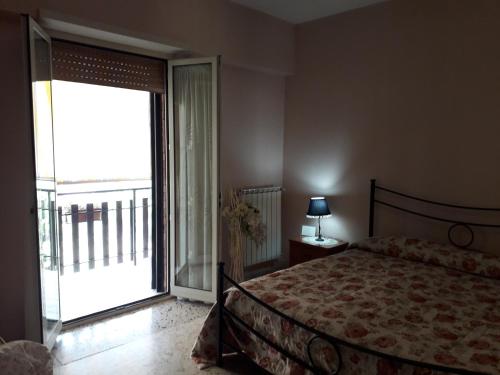 a bedroom with a bed and a large sliding glass door at casa Marilena in Tivoli