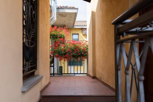 an alley with flowers hanging from a building at Maison Ancienne - Self check-in in Bergamo