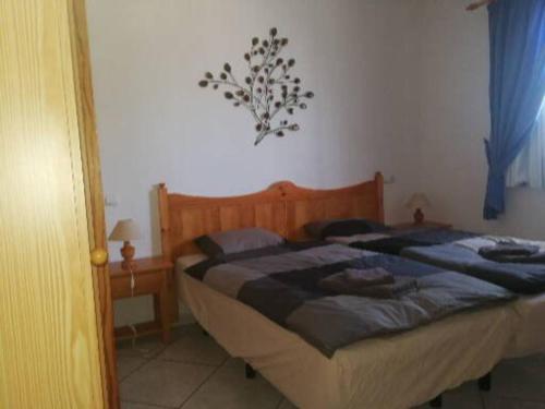 1 dormitorio con 1 cama con cabecero de madera en Casa Hibiscus sehr schönes Appartment zum relaxen, en Costa Calma