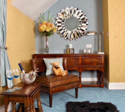 a teddy bear sitting on a chair in a room with a mirror at The Mainstay Luxury Boutique Rooms with Private Parking in Whitby