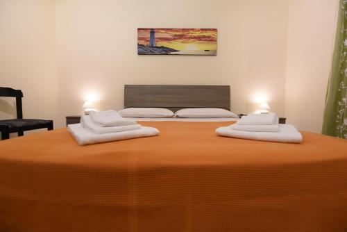 Una cama con dos toallas blancas encima. en La Casa Dei Sogni, en Siracusa