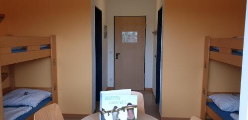 a room with two bunk beds and a sign in the middle at Jugendherberge Westerland in Westerland (Sylt)