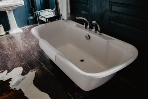 a white bath tub in a bathroom with a sink at Bellinter House Hotel & Spa in Navan