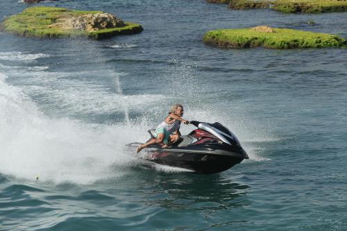 a woman riding a jet ski in the water at Cimer SafraMarine Beach Resort in Safra