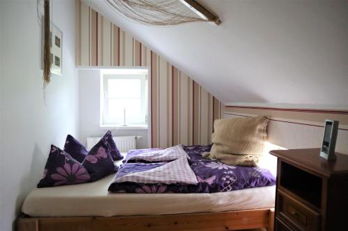 - une chambre avec un lit doté de draps violets et une fenêtre dans l'établissement Altes Gärtnerhaus, à Lübben