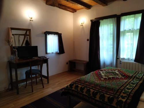 1 dormitorio con 1 cama y escritorio con ordenador en Dedovite Kashti, en Stefanovo