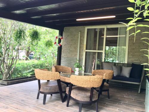 a patio with a table and chairs on a deck at Yosemite Homestay in Yuanshan