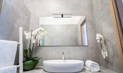 a bathroom with a white sink and a mirror at Svevo Sea House in Vieste