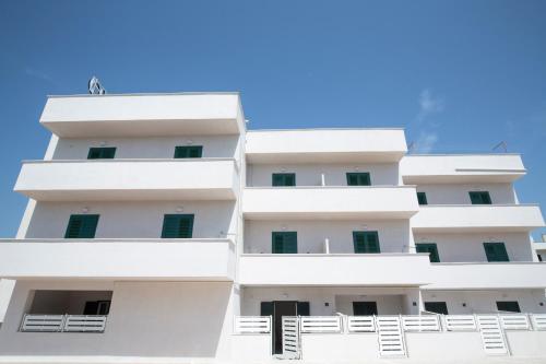 a building with white balconies against a blue sky at Svevo Sea House in Vieste