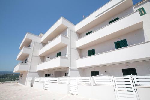 a white apartment building with white balconies at Svevo Sea House in Vieste