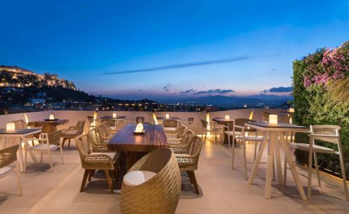 a dining area with tables and chairs and umbrellas at Central Hotel in Athens