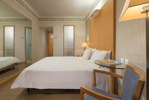 a hotel room with a large bed and a table at Central Hotel in Athens