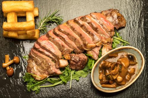 a plate of food with a sandwich and a bowl of mushrooms at Central Hotel in Athens