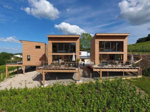 una casa con dos terrazas con mesas delante en COTTAGES ANTOINETTE en Chigny-les-Roses