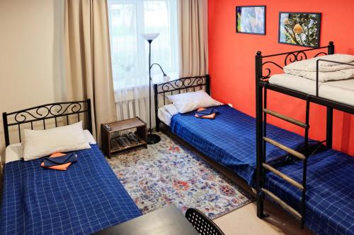 two beds in a room with red walls at DoBeDo Hostel in Yekaterinburg