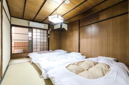 1 Schlafzimmer mit 2 Betten in einem Zimmer mit Holzwänden in der Unterkunft Kyomachiya Real Kyoto Wabisabi in Kyoto