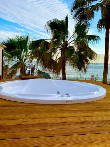 a large tub sitting on a deck next to the beach at Alaaddin Beach Hotel - Adult Only in Alanya