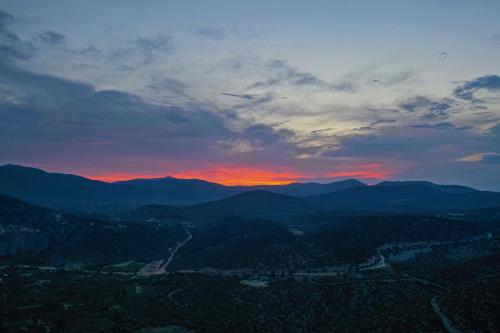 a sunset over a valley with mountains in the background at marilena in Néa Epídhavros
