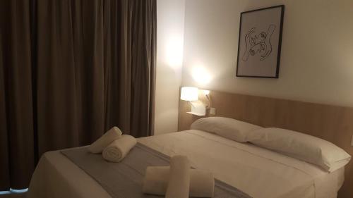 a bedroom with a bed with two white towels on it at Hotel Victori in Es Castell