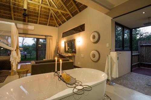 a large bathroom with a tub and a living room at Moya Safari Villa in Hoedspruit