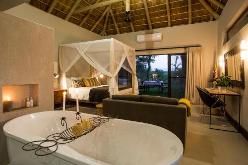 a room with a tub and a bedroom with a bed at Moya Safari Villa in Hoedspruit