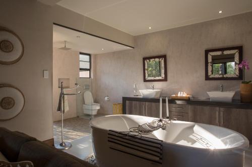 a large bathroom with a tub and two sinks at Moya Safari Villa in Hoedspruit
