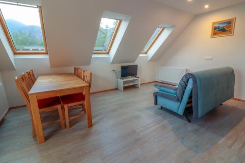 a attic room with a table and a chair and a desk at Apartments & Rooms Pr' Skalovc in Bohinj