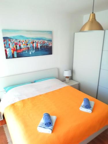 a bedroom with a bed with blue slippers on it at Apartment Pradini in Poljana